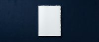 Blank white paper sheet on dark blue background for mockup design templates and presentations.