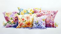 Decorative throw pillows with delicate floral patterns in watercolor style featuring soft pastels of pink, yellow, blue and purple on white backgrounds.
