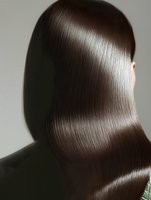 Back view of glossy straight brown hair showing smooth texture and shine against neutral background, demonstrating professional hair care results.