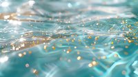 Turquoise ocean water surface with golden glitter bokeh effect and sunlight reflections creating magical underwater atmosphere. Dreamy aquatic background.