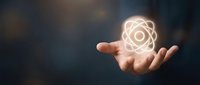 Scientist hand holding glowing atom symbol representing nuclear energy, physics research, and scientific innovation for educational and technology concepts.