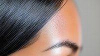 Close up portrait of Asian woman with flawless skin, dark eyebrows and black hair against orange background, focus on eye area. Professional beauty and cosmetics concept.