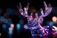 Crystal glass deer head illuminated by colorful neon lights against dark background with bokeh effect creates magical holiday atmosphere.