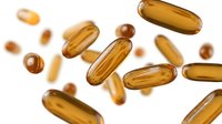 Golden vitamin capsules and pills floating on white background for health supplement and pharmaceutical design projects.