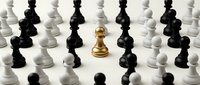 Golden chess pawn stands out among black and white pieces on white background. Leadership, strategy, uniqueness, success, business concept for presentations.