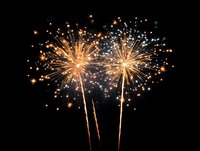Spectacular golden and white fireworks bursting against night sky, creating festive atmosphere for celebrations and holiday events.