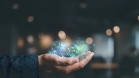 Close-up of hand holding glowing digital globe with network connections and data particles, representing global technology, connectivity, and digital transformation in business environment.
