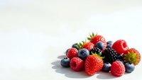 Fresh mixed berries including strawberries, blueberries, raspberries and blackberries arranged on white background for healthy eating and nutrition concepts.