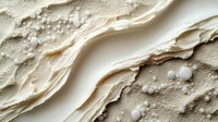 Shallow water flowing over sandy beach with foam patterns and wet sand textures, suitable for travel and nature backgrounds.