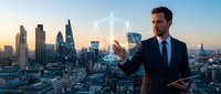 Professional businessman in suit touching holographic network interface against modern city skyline at sunset for technology and business concepts.