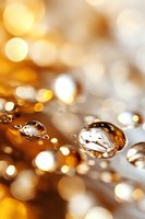 Macro photography of water drops with golden bokeh background creating magical atmosphere. Artistic nature abstract suitable for luxury designs and festive themes.