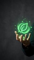 Hand holding glowing green leaf symbol with sparkling light effects representing eco-friendly technology, sustainability and environmental innovation concepts.