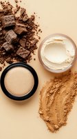 Crushed makeup powder, compact foundation and face cream on beige background. Cosmetic products with scattered bronzer and eyeshadow creating artistic composition.