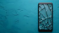 Broken smartphone screen with shattered glass pattern on turquoise textured background. Cracked display showing dramatic spider web fracture pattern. Modern device damage concept.