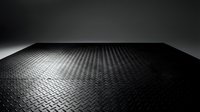 Black diamond plate metal floor with perspective view, industrial surface texture for backgrounds and design projects.