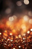 Glowing orange and gold bokeh lights create magical festive atmosphere with blurred sparkles and circles on dark background for holiday designs.