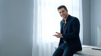 Professional businessman in dark suit using smartphone in modern office with natural window light for corporate communication and business technology.