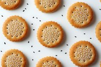 Round butter cookies with white pearl sugar and black sesame seeds on white background. Fresh homemade shortbread biscuits arranged in pattern for bakery or food design.