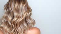 Luxurious wavy blonde balayage hair with soft highlights and natural waves styled on light background, showing professional hairstyling technique and modern color trends.