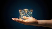Glowing circuit board cube held in open palm against dark background, representing technology innovation, digital transformation, and future computing solutions.
