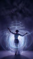 Woman with outstretched arms surrounded by glowing energy circles and light effects against dark mystical background for spiritual meditation concepts.