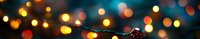 Glowing orange and blue bokeh lights create magical festive atmosphere with blurred Christmas decorations in dark background. Soft focus holiday backdrop.