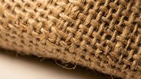 Natural burlap fabric texture with woven jute fibers showing rustic organic material for eco-friendly packaging and craft projects.
