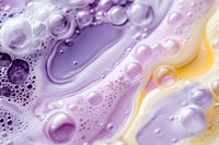 Abstract liquid bubbles in purple and yellow gradient with water droplets creating flowing organic patterns for modern design backgrounds.