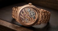 Luxury rose gold mechanical watch with exposed gears and ornate engraved bracelet on dark surface for premium timepiece and jewelry advertising.