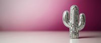 Decorative silver metallic cactus sculpture on minimalist pink gradient background for modern interior design and home decor concepts.