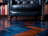 Luxurious black leather armchair with brass studs against bookshelf background, low angle view focusing on parquet flooring with rich wood tones and blue inlays.