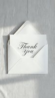 Elegant thank you card in calligraphy script tucked in a white envelope on a soft linen background, perfect for wedding and event stationery.