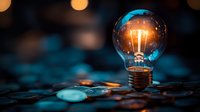 Glowing light bulb with warm filament on reflective surface with colorful bokeh lights in background creating innovative technology and creativity concept.