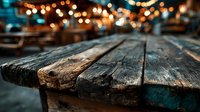 Rustic wooden table surface with warm bokeh lights background for product display and festive holiday decorations.