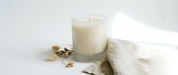 Luxury spa wellness scene with burning candle, soft towels and golden jewelry creating peaceful relaxation atmosphere for self-care and meditation rituals.