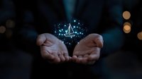 Glowing sailboat hologram floating above cupped hands in dark setting with bokeh lights, magical fantasy concept for travel and adventure dreams.