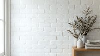 Minimalist interior design with white brick wall, dried eucalyptus branches in ceramic vase on wooden shelf creating serene scandinavian home decor atmosphere.