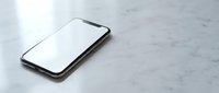 Modern black smartphone with blank white screen lying on marble surface for mockup and app presentation purposes.