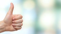 Hand showing thumbs up gesture against soft blurred background expressing approval, success and positive feedback for business and communication concepts.