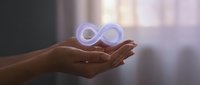 Hands holding glowing infinity symbol representing endless possibilities, eternal concepts, and limitless potential in soft ambient lighting.