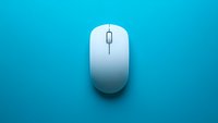 Minimalist white wireless computer mouse on vibrant turquoise background, creating modern tech contrast for business and office concepts.
