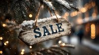 Rustic wooden SALE sign hanging on snowy pine branch with festive bokeh lights creating warm holiday shopping atmosphere.