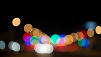 Abstract colorful bokeh lights background with soft glowing circles in warm and cool tones creating dreamy atmosphere for festive celebrations.