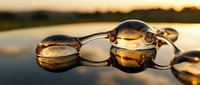 Stylish brown sunglasses reflecting golden sunset light on smooth surface creating warm atmospheric mood for summer vacation and outdoor lifestyle concepts.