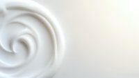 Creamy white swirl texture with smooth flowing curves on soft beige background for cosmetic and skincare product design applications.