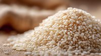 Pile of raw sesame seeds on burlap sack background, organic healthy ingredient for cooking and baking applications in food industry and culinary preparations.