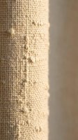 Natural burlap fabric texture with water droplets on woven jute surface for eco-friendly packaging and rustic craft projects.