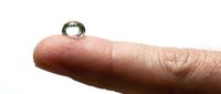 A single water droplet rests on a human finger against a white background, showcasing liquid surface tension and hydration concepts for science and wellness content.