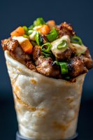 Grilled meat wrap with fresh vegetables and herbs in tortilla on dark background for restaurant menu and food photography.