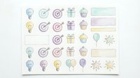 Colorful hand-drawn planner stickers featuring light bulbs, targets, gifts, cupcakes, balloons and stars with pastel colors for bullet journaling.